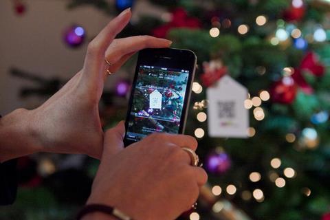 Shoppers use smartphones to scan QR codes to buy